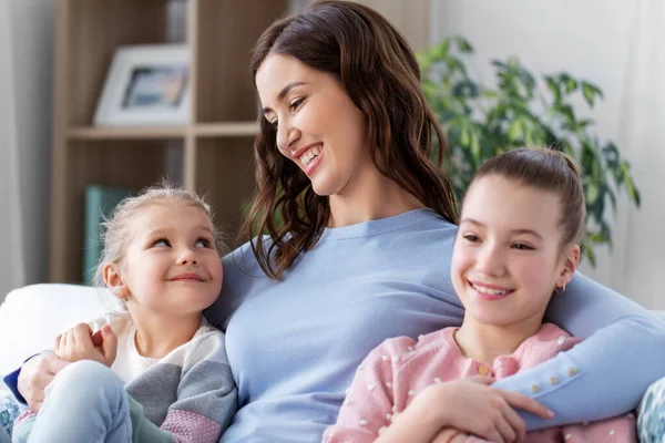 Šťastná usměvavá matka se dvěma dcerami doma — Stock fotografie