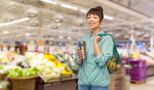 Vrouw met thermo cup of tuimelaar voor warme dranken Stockafbeelding