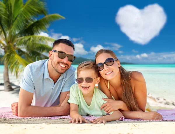 Famiglia felice sdraiato su sfondo spiaggia tropicale — Foto Stock