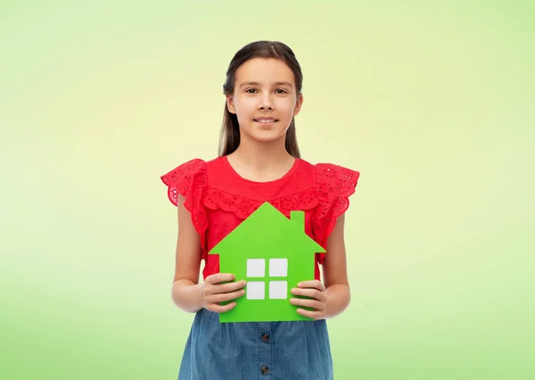 Glimlachend klein meisje met groene huis pictogram — Stockfoto