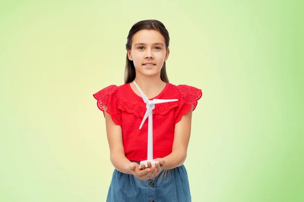 Sorrindo menina com brinquedo turbina eólica sobre verde — Fotografia de Stock