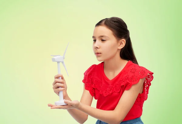 Leende flicka med leksak vindkraftverk över grön — Stockfoto