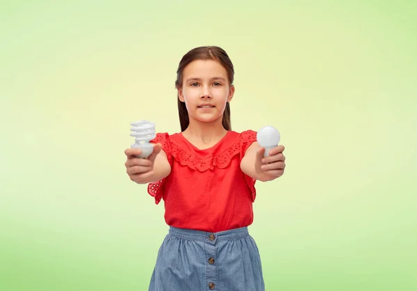 Sorridente ragazza confrontando diverse lampadine — Foto Stock