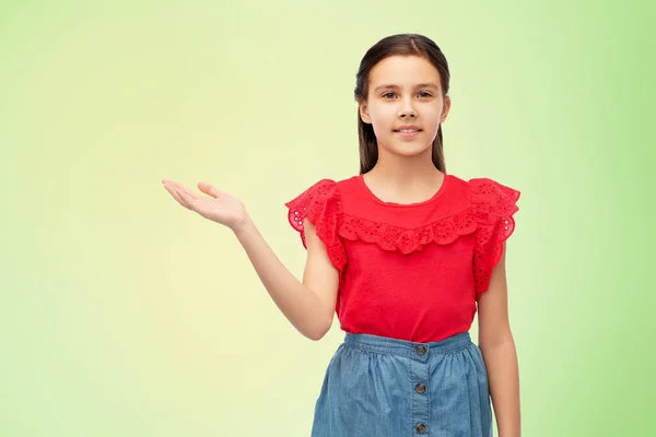 Glad leende flicka håller något på handen — Stockfoto