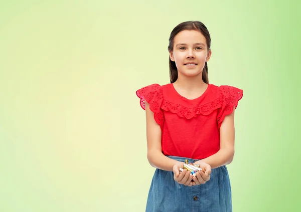 Lächelndes Mädchen mit einem Stapel Alkaline-Batterien — Stockfoto