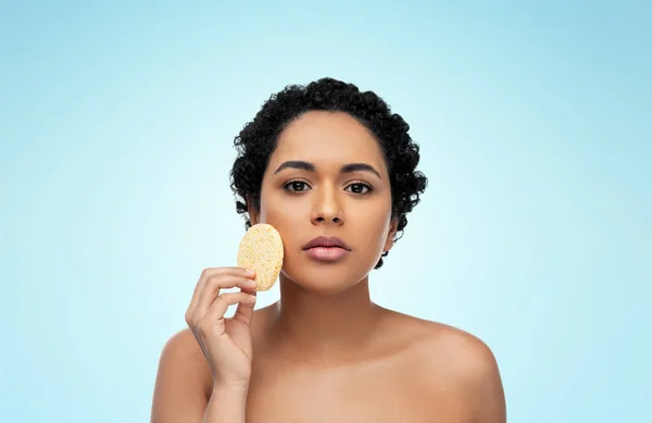 Junge Frau reinigt Gesicht mit Peeling-Schwamm — Stockfoto