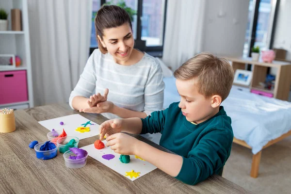 Mãe e filho brincando com argila modelagem em casa — Fotografia de Stock