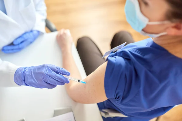 Arts met injectiespuit die medisch werker vaccineert — Stockfoto