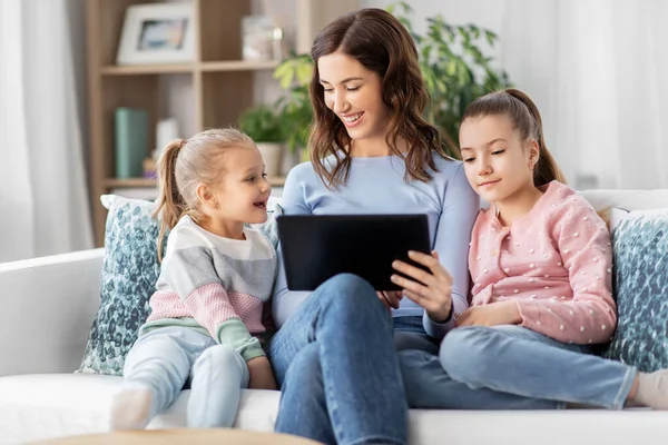 Felice madre e figlie con tablet pc a casa — Foto Stock