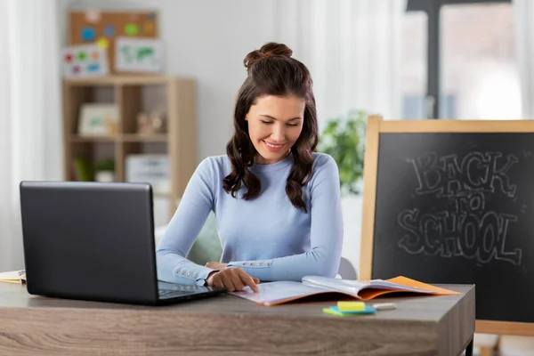 Leraar met laptop en notebook werken vanuit huis — Stockfoto