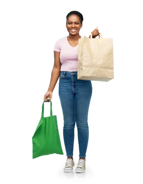 Kobieta porównująca torby wielokrotnego użytku z papierowymi — Zdjęcie stockowe
