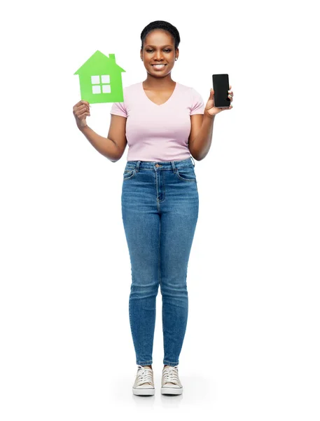 Afrikaanse vrouw met smartphone en groene huis — Stockfoto