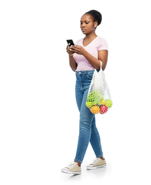 Mujer con smartphone y comida en bolsa de cuerda — Foto de Stock