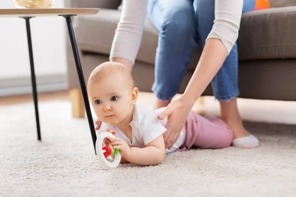 Mother and baby playing with rattle at home — Stock Photo, Image