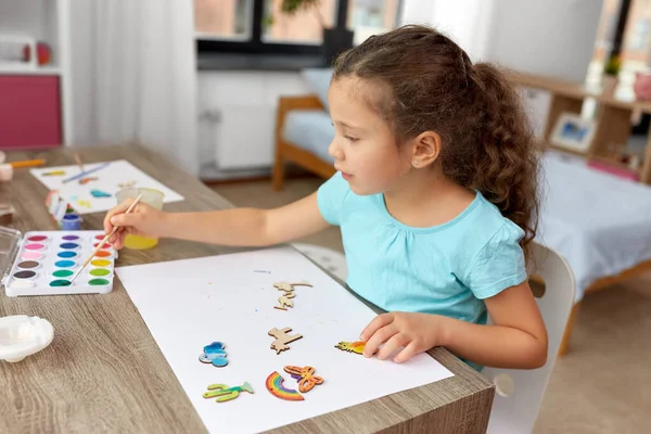 Κοριτσάκι ζωγραφική ξύλινα αντικείμενα στο σπίτι — Φωτογραφία Αρχείου