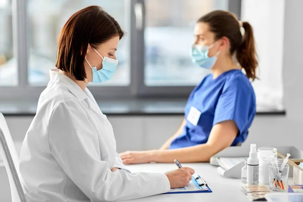 Doctor with clipboard and nurse at hospital — Stock Photo, Image