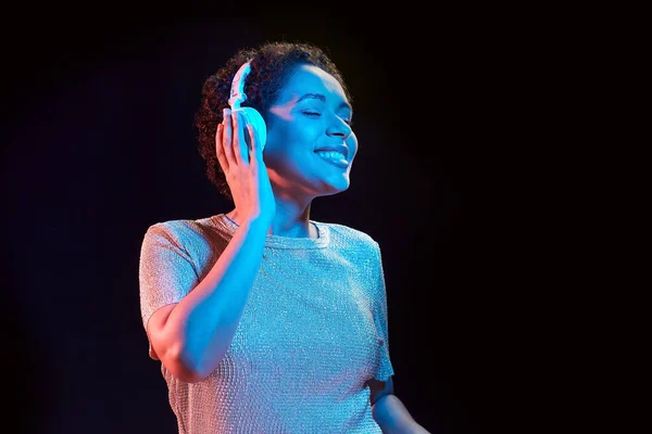 Vrouw in hoofdtelefoon luisteren naar muziek en dansen — Stockfoto