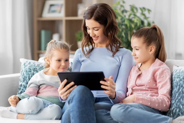 Mãe feliz e filhas com tablet pc em casa — Fotografia de Stock