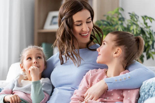 Glücklich lächelnde Mutter mit zwei Töchtern zu Hause — Stockfoto