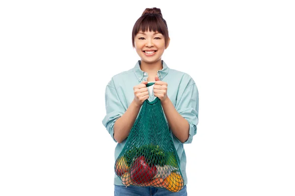 Happy asian woman with food in reusable string bag — Stock Photo, Image