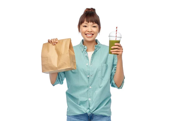 Glücklich asiatische Frau mit Getränk und Essen in Papiertüte — Stockfoto