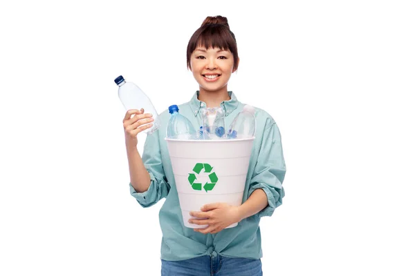Улыбающаяся молодая азиатка сортирует пластиковые отходы — стоковое фото