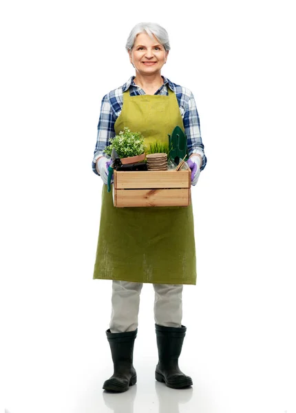 Uśmiechnięta starsza kobieta z narzędziami ogrodowymi w pudełku — Zdjęcie stockowe