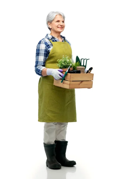 Femme âgée souriante avec outils de jardin en boîte — Photo