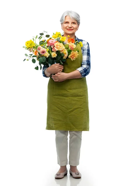 Mosolygós idős nő kerti kötény virágokkal — Stock Fotó
