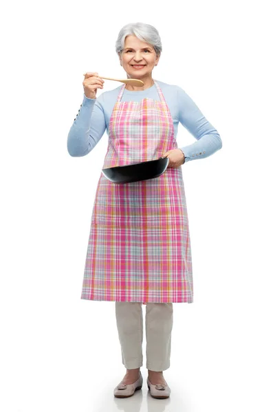 Mulher sênior sorridente em avental com frigideira — Fotografia de Stock
