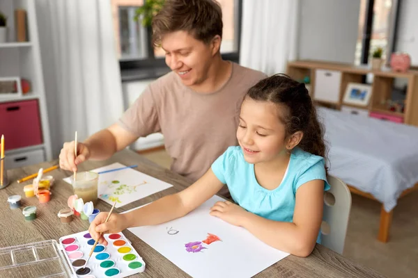 Feliz padre con hija pequeña dibujando en casa —  Fotos de Stock