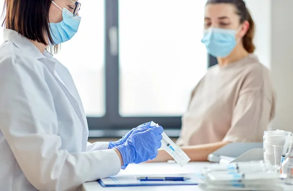 Femme médecin avec seringue et patiente à l'hôpital — Photo