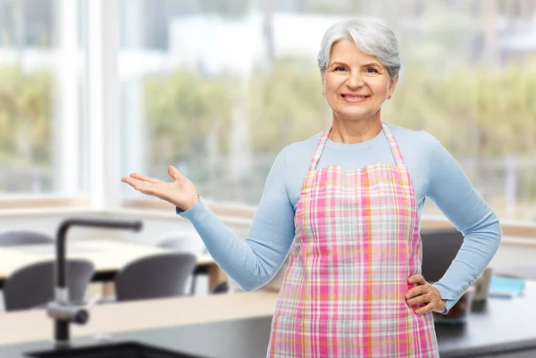 Ritratto di donna anziana sorridente in grembiule a casa — Foto Stock