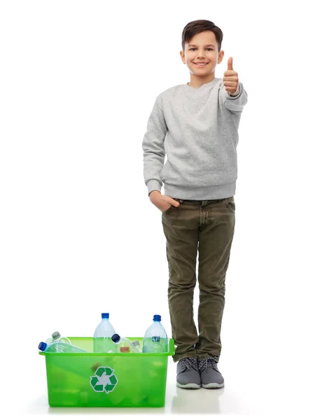 Улыбающийся мальчик сортирует пластиковые отходы — стоковое фото