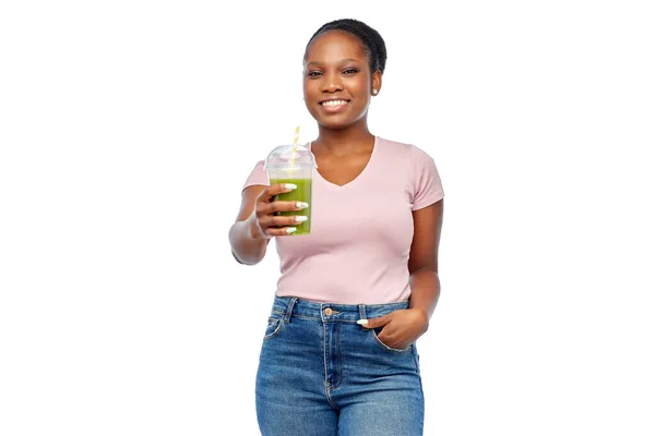 Feliz afro-americana bebendo suco verde — Fotografia de Stock