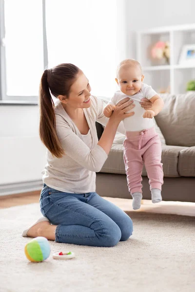 Feliz madre jugando con pequeño bebé en casa —  Fotos de Stock