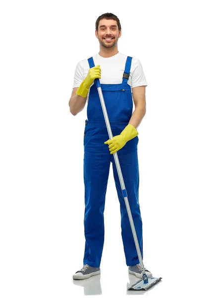 Male cleaner in overall cleaning floor with mop — Stock Photo, Image