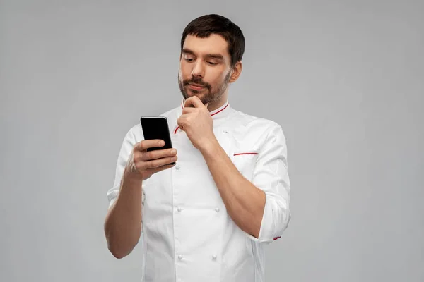 Chef masculino pensante con smartphone — Foto de Stock