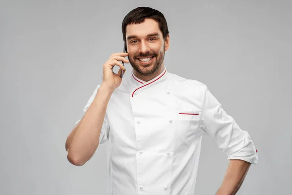 Glücklich lächelnder männlicher Koch telefoniert mit dem Smartphone — Stockfoto
