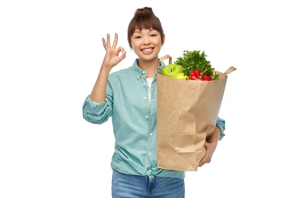 Счастливая азиатка с едой в бумажном пакете — стоковое фото