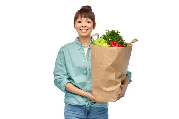 Glückliche asiatische Frau mit Lebensmitteln in Papiereinkaufstasche — Stockfoto