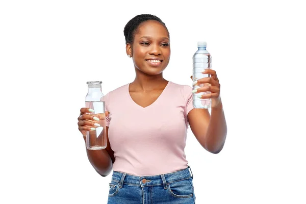Szczęśliwa kobieta z plastikiem i szklaną butelką wody — Zdjęcie stockowe