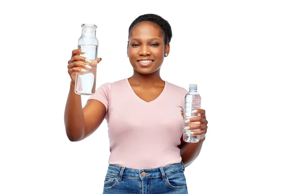 Glückliche Frau mit Plastik- und Glasflasche Wasser — Stockfoto