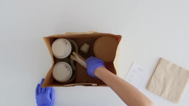 Manos en guantes embalaje comida para llevar para el cliente — Vídeo de stock