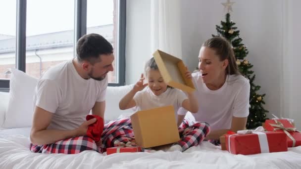 Lycklig familj med julklappar i sängen hemma — Stockvideo