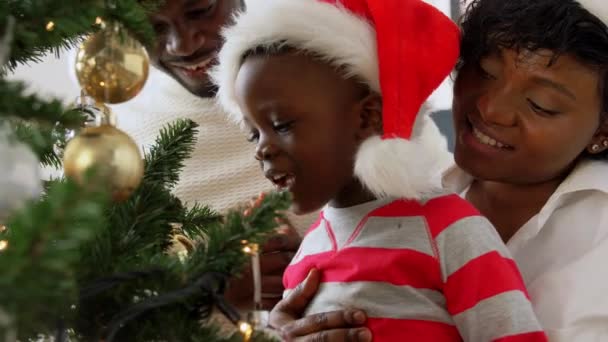 Gelukkig familie versieren kerstboom thuis — Stockvideo