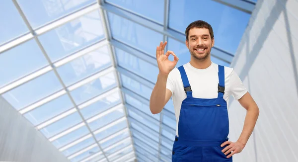 Feliz macho trabajador mostrando ok en glasshouse — Foto de Stock