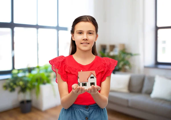 Smiling girl holding house model at home — Stock Photo, Image