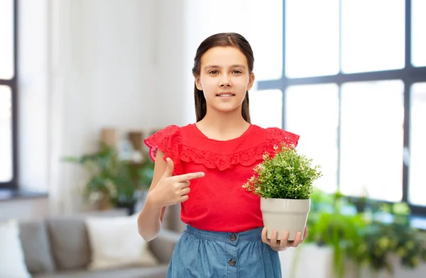 Gelukkig lachend meisje houden bloem in pot thuis — Stockfoto