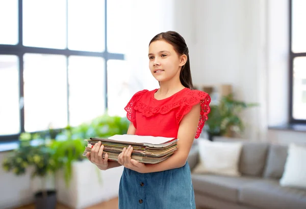 Dergileri olan bir kız evde kağıt atıkları düzenliyor. — Stok fotoğraf
